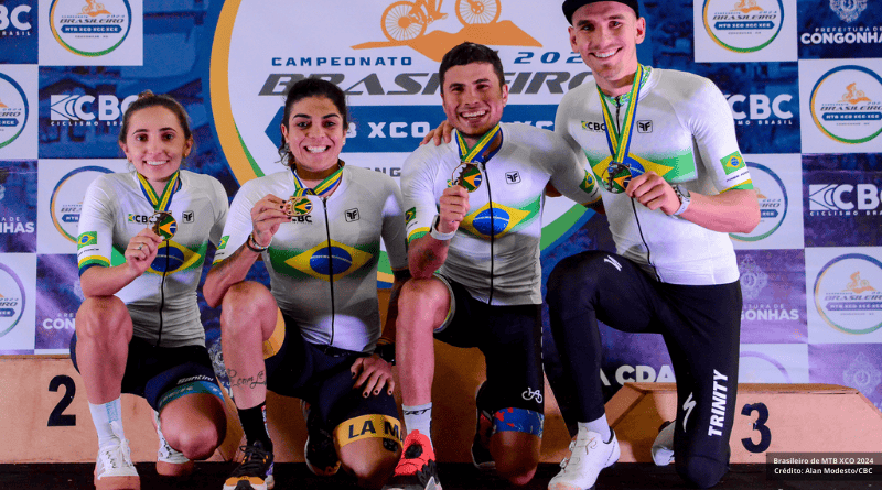 4 atletas apresentando suas medalhas